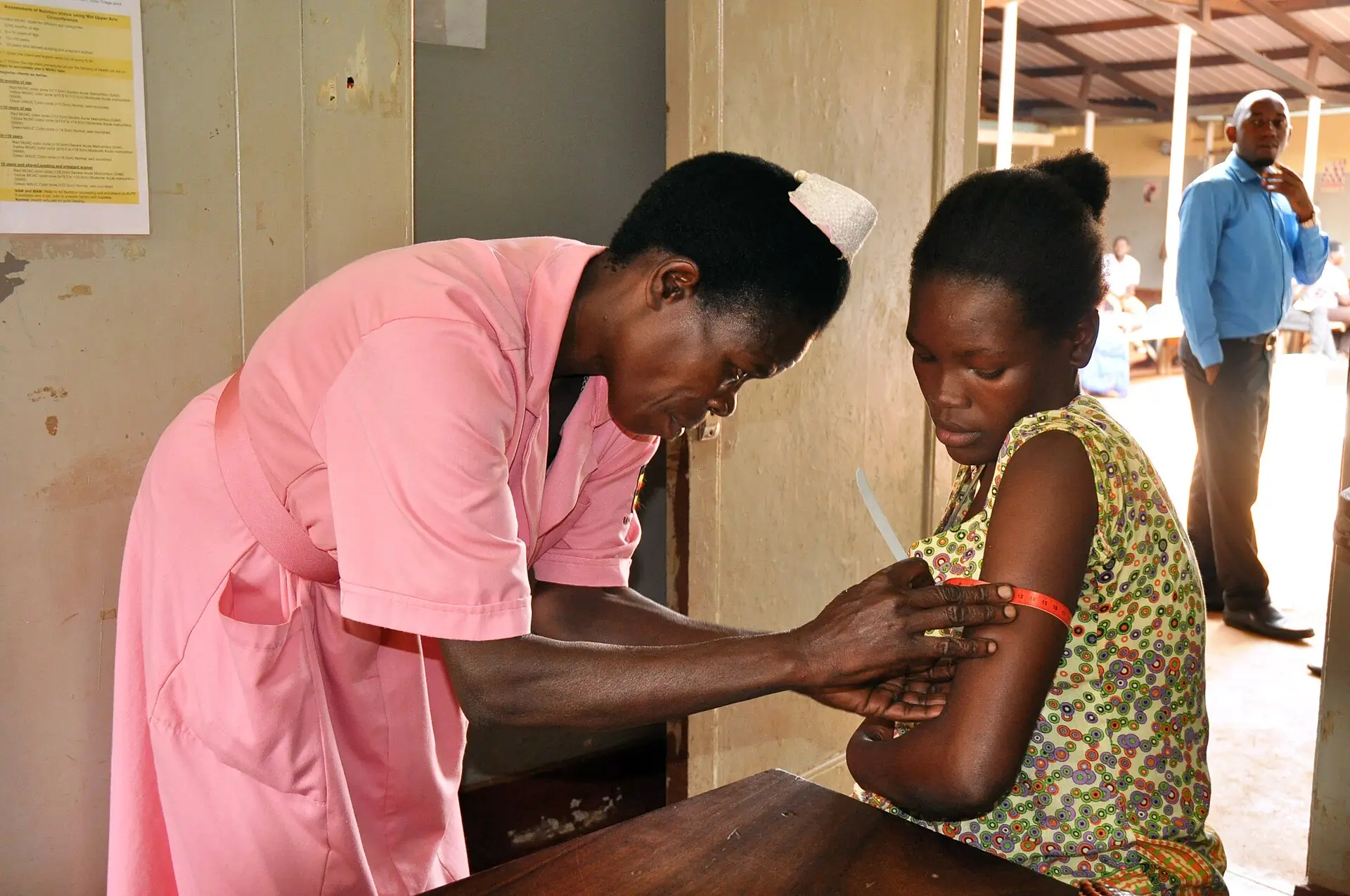A health worker measures the upper arm of a young woman during a nutrition check. Illustrative photo.