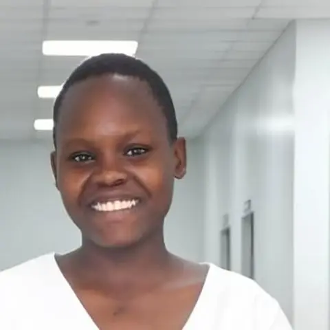 Lilian, a teenage girl, smiling in a hospital corridor.